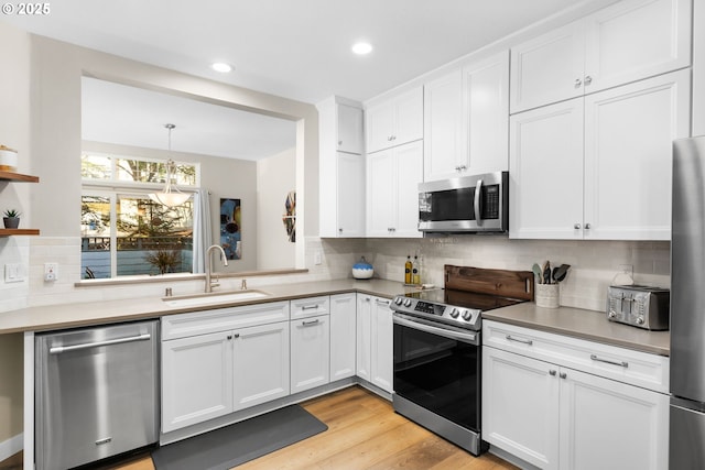 9619 NW Silver Ridge Loop, Portland, OR 97229 - kitchen with stainless steel appliances, a sink, white cabinetry, open shelves, and decorative backsplash