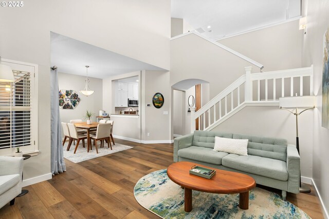 9619 NW Silver Ridge Loop, Portland, OR 97229 - living room featuring dark wood-style floors, arched walkways, and stairway