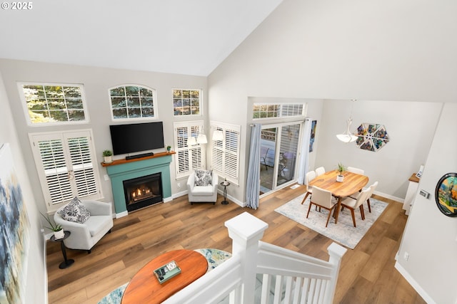 9619 NW Silver Ridge Loop, Portland, OR 97229 - living room featuring a warm lit fireplace, high vaulted ceiling, wood finished floors, and baseboards