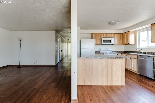 786788 W Quinalt St, Springfield, OR 97477 - kitchen with white appliances, dark wood-style floors, dark stone countertops, a textured ceiling, and a kitchen island