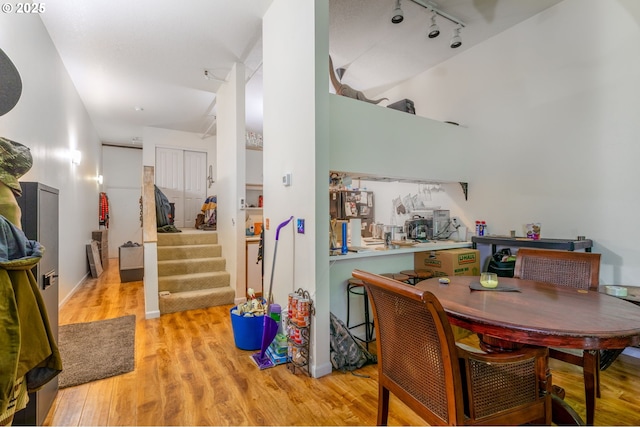 1910 SW 18th Ave Unit 23, Portland, OR 97201 - dining area featuring track lighting, light wood-type flooring, stairway, and a towering ceiling