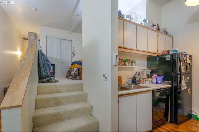 1910 SW 18th Ave Unit 23, Portland, OR 97201 - kitchen with black appliances, light countertops, light wood finished floors, and white cabinetry