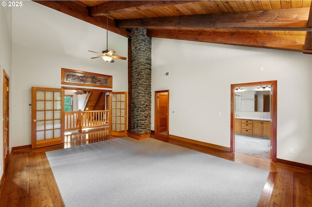 unfurnished living room featuring baseboards, hardwood / wood-style floors, wooden ceiling, a ceiling fan, and high vaulted ceiling