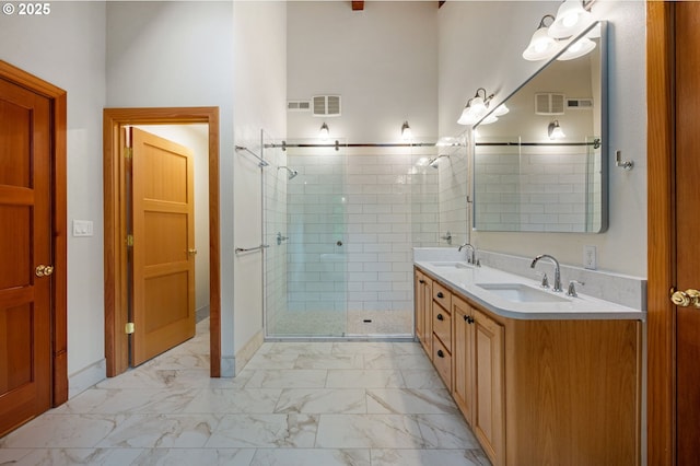 bathroom featuring marble look tile flooring, a shower stall, and double vanity