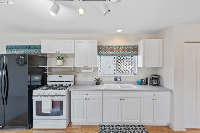 6 Creek Ln, Lakeside, OR 97449 - kitchen featuring white gas range, a sink, white cabinetry, light countertops, and freestanding refrigerator