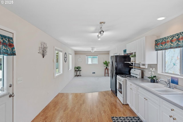 6 Creek Ln, Lakeside, OR 97449 - kitchen featuring white range with gas cooktop, a sink, white cabinetry, and light countertops