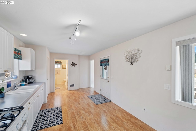 6 Creek Ln, Lakeside, OR 97449 - kitchen with a sink, light wood-type flooring, white cabinetry, and plenty of natural light