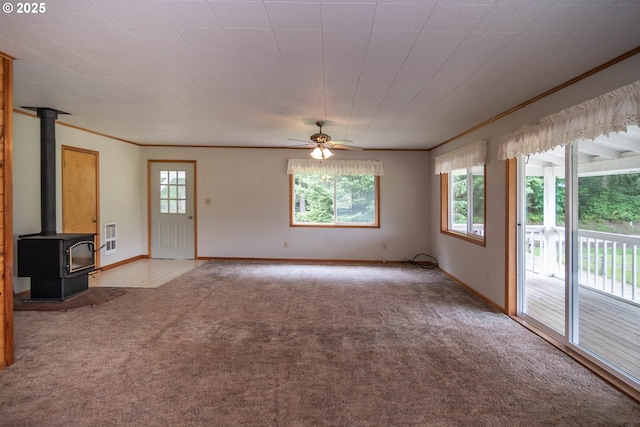 3333 Bullock Rd, Oakland, OR 97462 - unfurnished living room featuring carpet, a wood stove, ceiling fan, crown molding, and heating unit