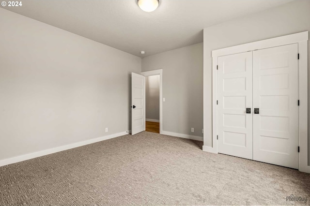 unfurnished bedroom featuring carpet flooring and a closet