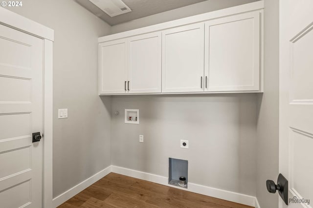 laundry room with hookup for an electric dryer, cabinets, wood-type flooring, and hookup for a washing machine