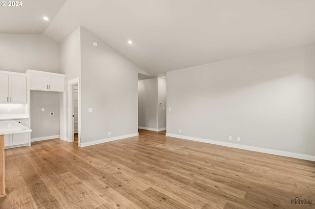 unfurnished living room featuring light hardwood / wood-style floors and high vaulted ceiling