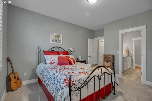 bedroom featuring light carpet and ensuite bathroom