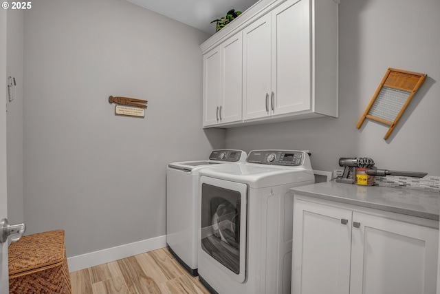 washroom featuring light hardwood / wood-style floors, cabinets, and washing machine and dryer