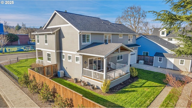 back of house with a lawn, central AC, and a storage unit