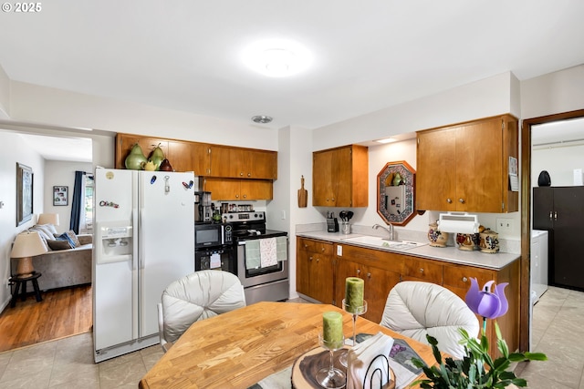 17222 SW Blanton St, Beaverton, OR 97078 - kitchen with white fridge with ice dispenser, stainless steel range with electric cooktop, brown cabinets, light countertops, and black microwave