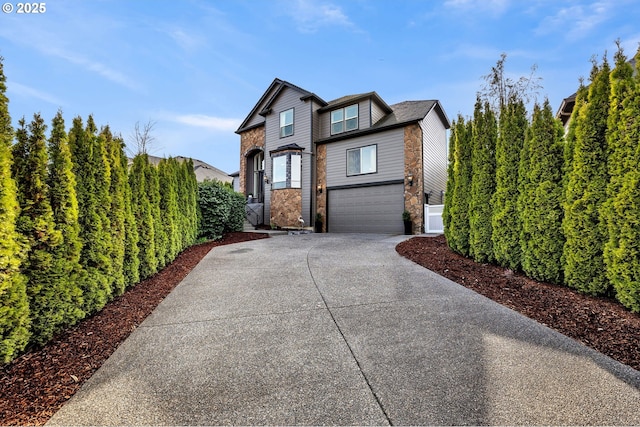 view of side of home featuring an attached garage, fence, stone siding, and driveway