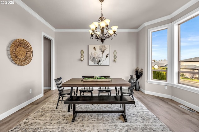 dining area with wood finished floors, visible vents, and ornamental molding