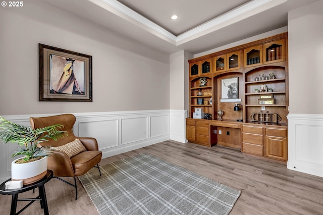 sitting room featuring recessed lighting, a raised ceiling, light wood-style flooring, and built in study area