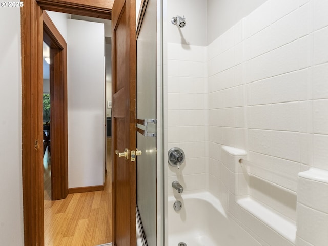 bathroom with wood finished floors and shower / tub combination