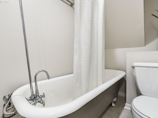 full bathroom with a washtub, tile patterned flooring, and toilet