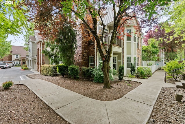 view of side of home with brick siding and fence