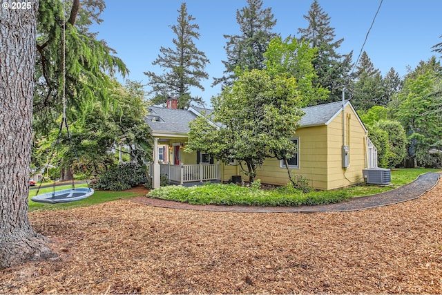 3900 SW Dolph Ct, Portland, OR 97219 - view of front of home featuring cooling unit, a shingled roof, covered porch, and a chimney