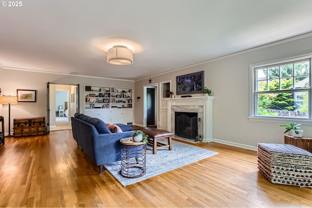 3900 SW Dolph Ct, Portland, OR 97219 - living room featuring wood finished floors, a fireplace, ornamental molding, and baseboards