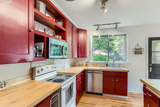 3900 SW Dolph Ct, Portland, OR 97219 - kitchen featuring stainless steel appliances, a sink, light wood-style flooring, wooden counters, and reddish brown cabinets