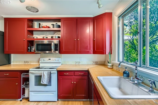 3900 SW Dolph Ct, Portland, OR 97219 - kitchen featuring stainless steel microwave, white electric range oven, a sink, and butcher block countertops