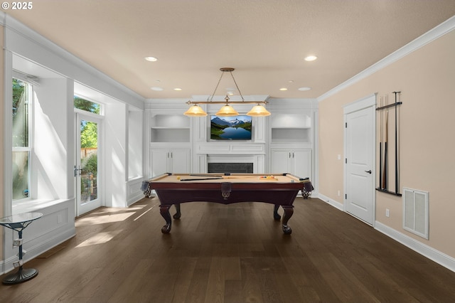 game room featuring dark hardwood / wood-style floors, pool table, a fireplace, and crown molding