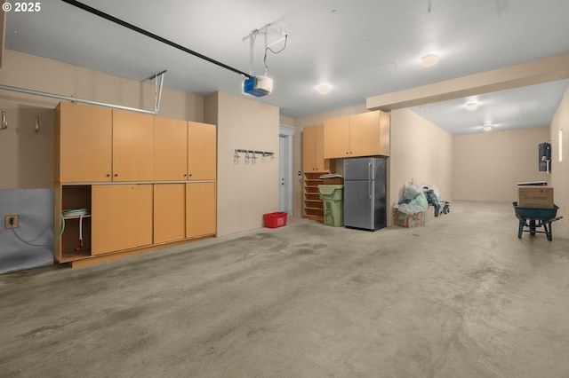 garage featuring a garage door opener and stainless steel fridge