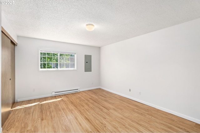 6654 SW Capitol Hwy, Portland, OR 97219 - unfurnished bedroom featuring a baseboard radiator, electric panel, light wood finished floors, baseboards, and a textured ceiling
