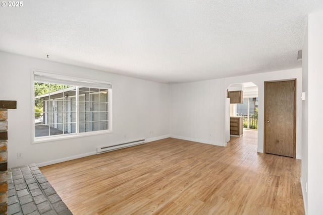 6654 SW Capitol Hwy, Portland, OR 97219 - unfurnished living room featuring a baseboard heating unit, arched walkways, a textured ceiling, light wood-style floors, and baseboards