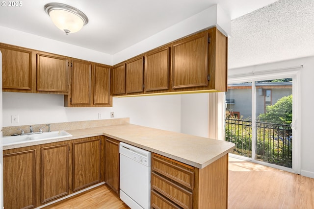 6654 SW Capitol Hwy, Portland, OR 97219 - kitchen featuring white dishwasher, a sink, light countertops, and brown cabinetry