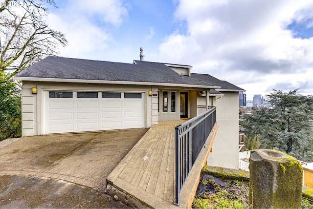 view of front of property featuring an attached garage, driveway, and roof with shingles