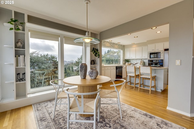 dining room with recessed lighting, light wood-style floors, and baseboards