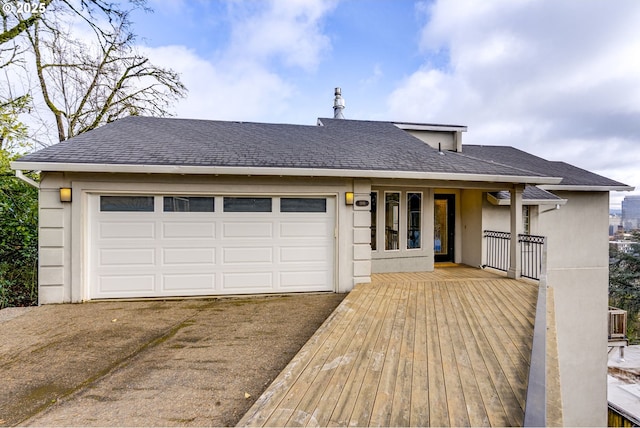 view of front facade featuring stucco siding, driveway, an attached garage, and a shingled roof