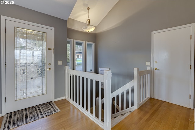 entryway featuring vaulted ceiling, wood finished floors, and baseboards