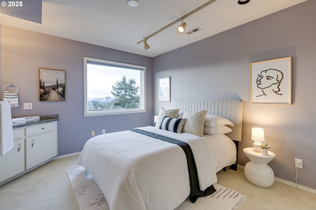 bedroom with visible vents, light carpet, baseboards, and track lighting