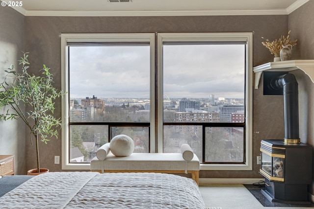 bedroom with a view of city, carpet flooring, a wood stove, and ornamental molding