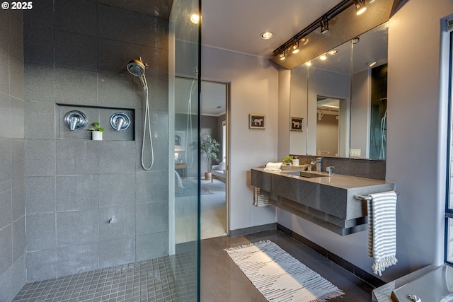 full bathroom featuring a walk in shower, vanity, and baseboards