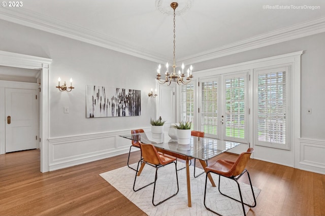 dining area with ornamental molding, a chandelier, and hardwood / wood-style floors