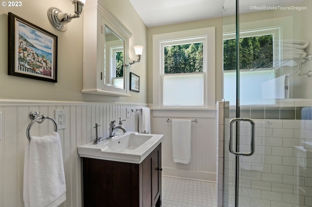 bathroom featuring tile patterned flooring, an enclosed shower, and vanity