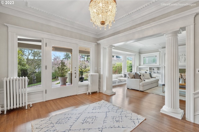 sunroom featuring radiator heating unit and an inviting chandelier