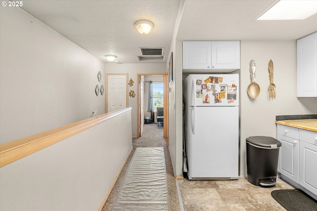 15745 NE Beech St, Portland, OR 97230 - kitchen with freestanding refrigerator, white cabinets, a textured ceiling, and light countertops