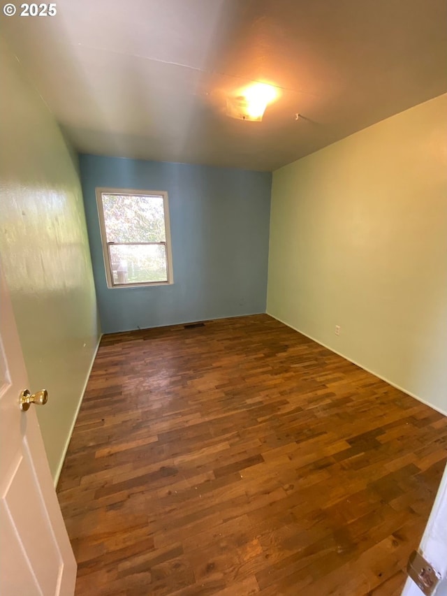 unfurnished room featuring dark wood-type flooring