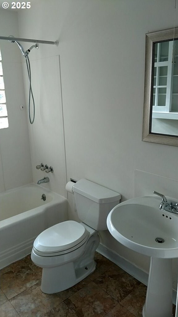 bathroom with tub / shower combination and toilet