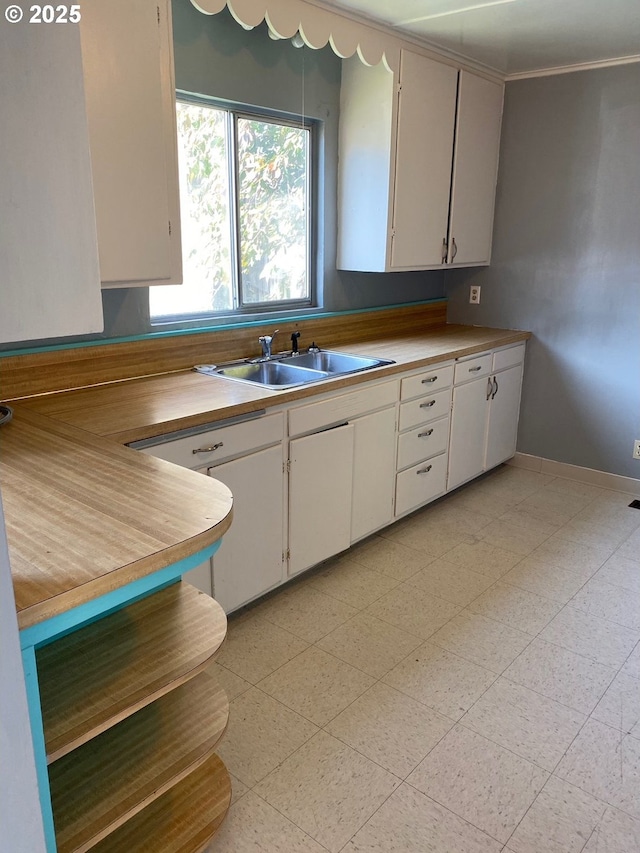 kitchen featuring sink and white cabinetry