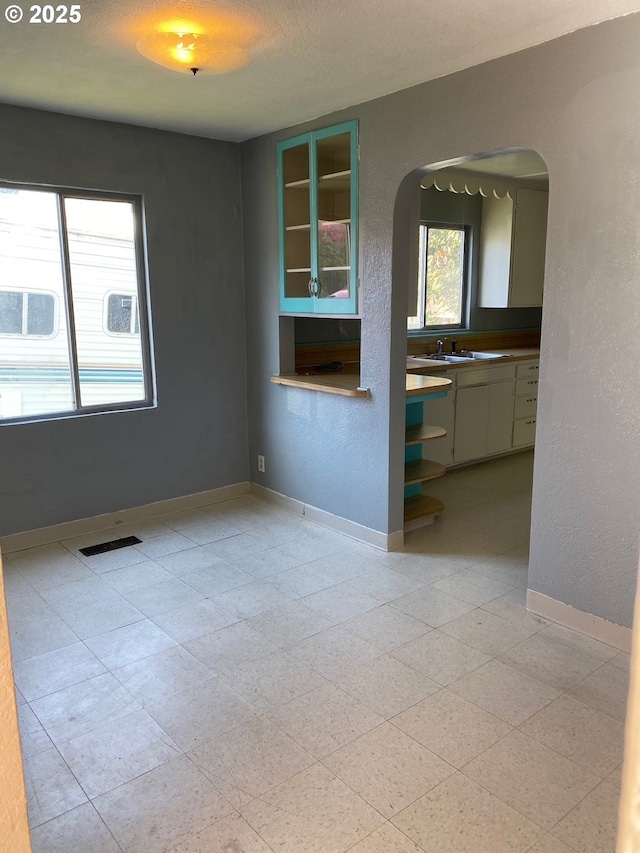 unfurnished room featuring a textured ceiling and sink