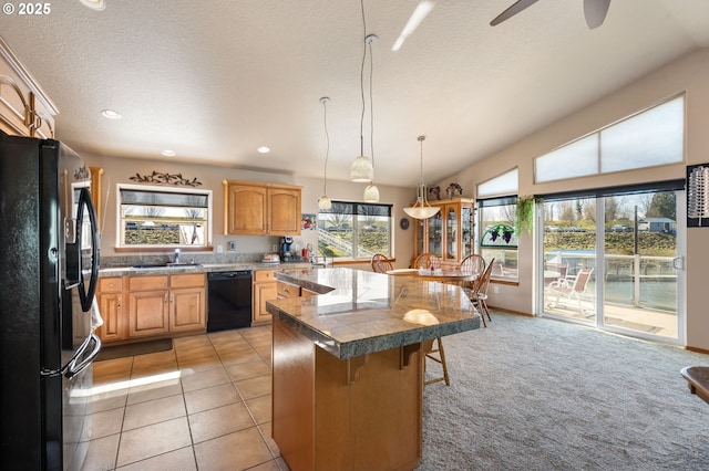 kitchen with a kitchen bar, a center island, lofted ceiling, black appliances, and ceiling fan